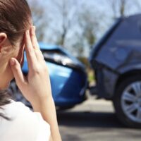 Young Woman Viewing Scene Of Rear End Car Accident