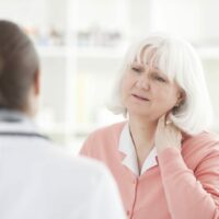 Elderly Woman With A Whiplash Injury Stock Photo