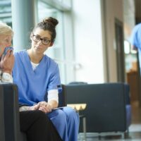 Nurse Consoling An Elderly Woman Stock Photo