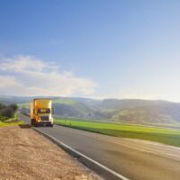 Yellow Semi-Truck Driving Stock Photo