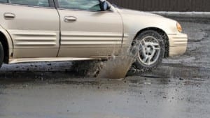 Car Hitting A Pothole On A City Street